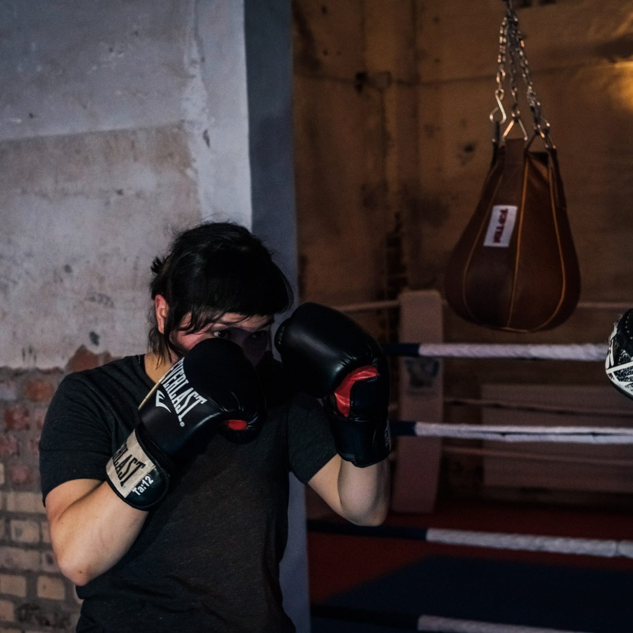 Eine Person hat die Deckung oben und Boxhandschuhe an